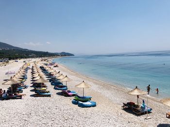 Aireal view with umbrellas and sun beds in a rocky beach in albania.