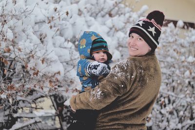 Small boy and mother enjoying the fresh snow outside