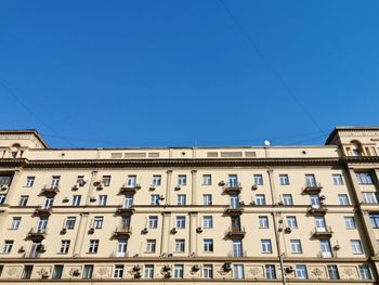 Low angle view of buildings against clear blue sky