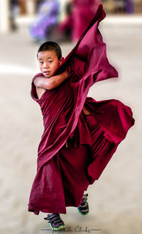 Portrait of monk walking on footpath 