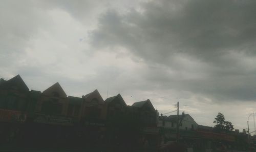 Houses against cloudy sky