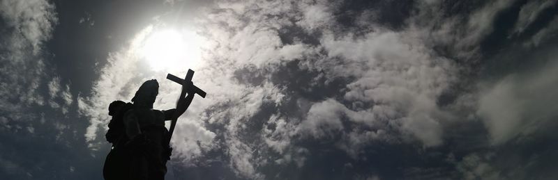 Low angle view of silhouette statue against sky