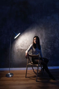 Young woman standing by wall