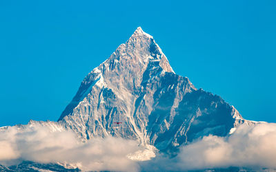 Scenic view of snowcapped mountains against clear blue sky