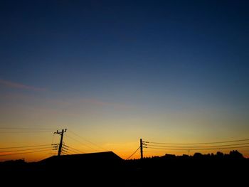 Low angle view of silhouette electricity pylon against romantic sky