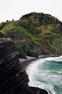 Scenic view of sea by mountains against clear sky