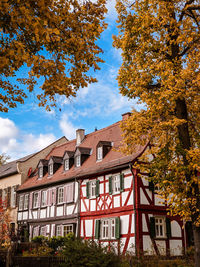 Low angle view of trees and buildings against sky