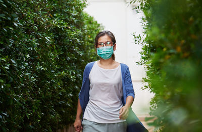 Portrait of young woman against plants