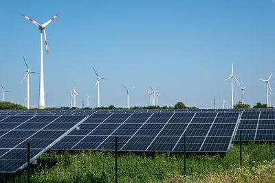 Solar panels on field against clear sky