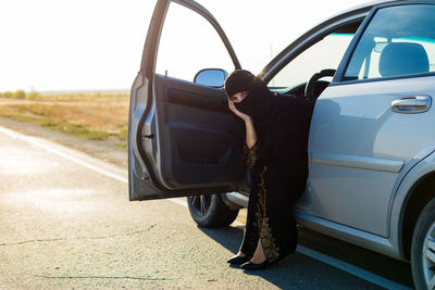 A brunette woman looks out of the window of an actomobile.