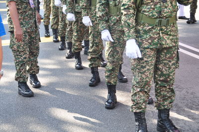 Low section of army soldiers wearing uniform standing on street in city