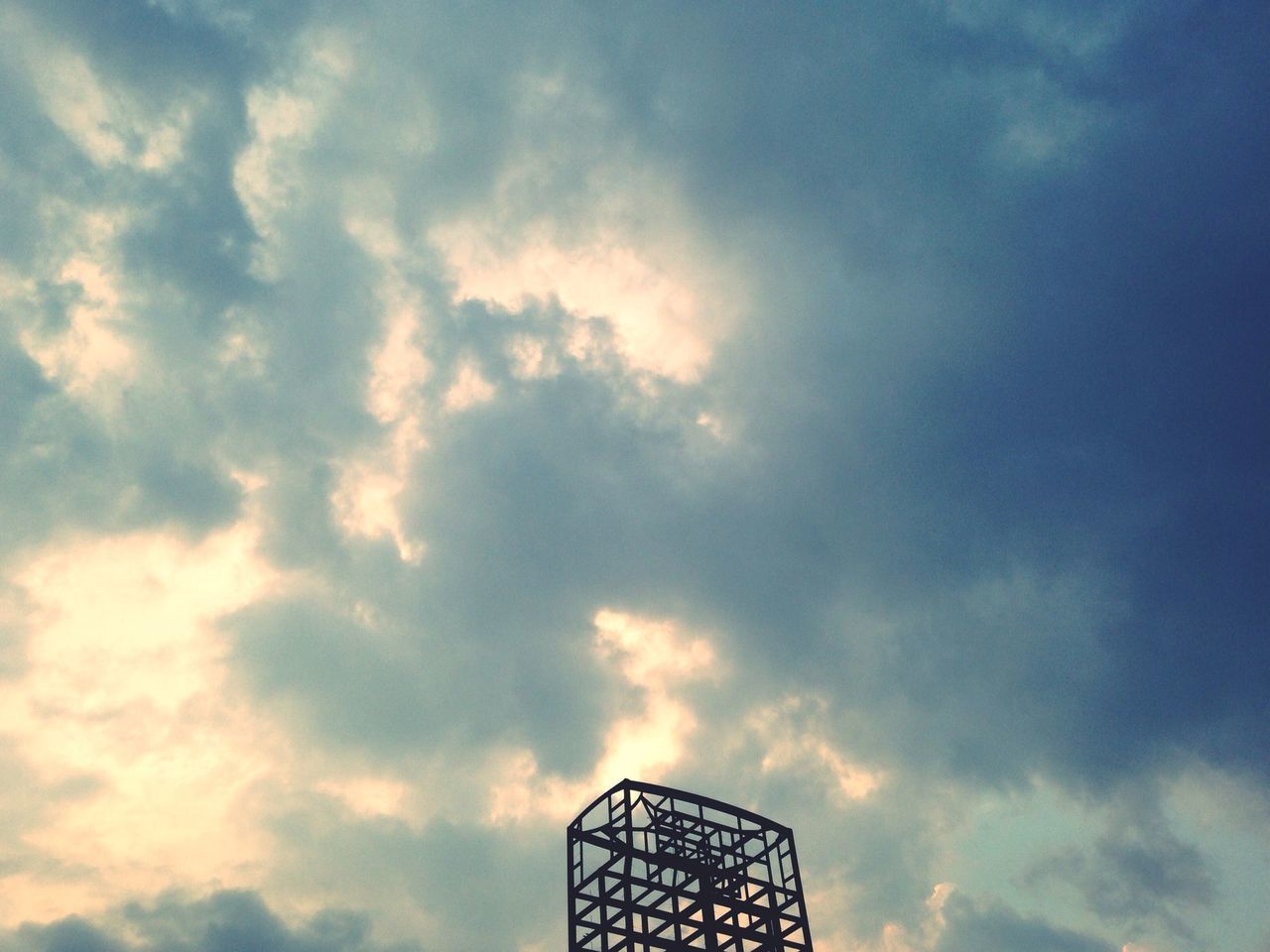 low angle view, sky, cloud - sky, cloudy, cloud, built structure, silhouette, metal, architecture, outdoors, no people, nature, high section, day, sunset, metallic, modern, weather, overcast, part of