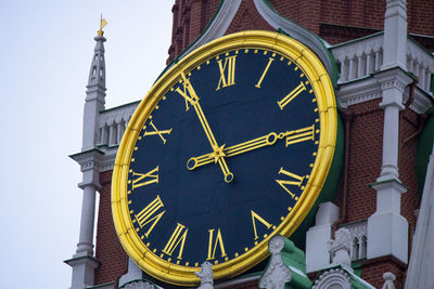 Low angle view of clock on building against sky