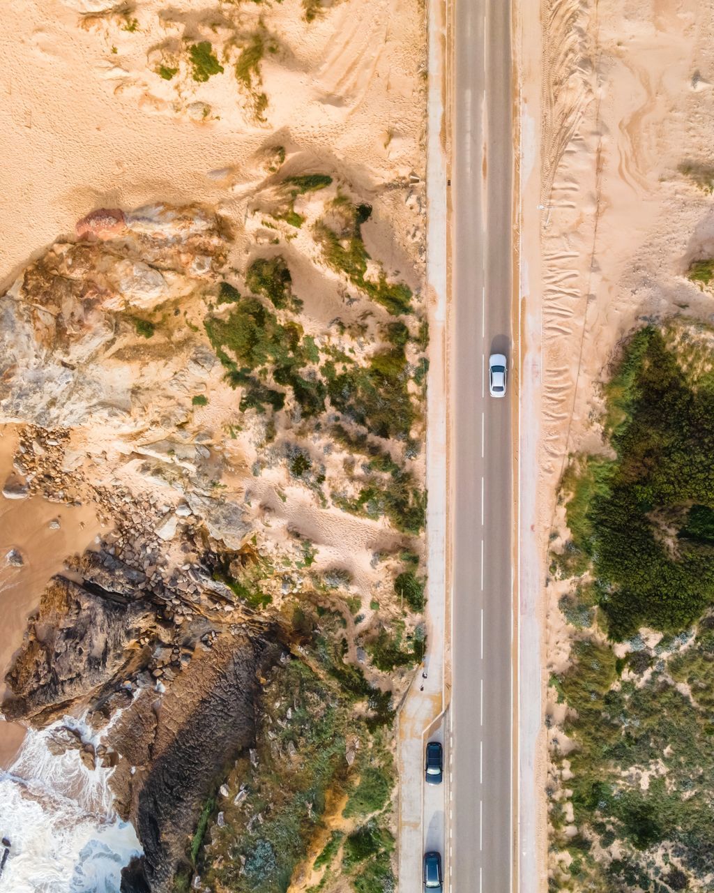 HIGH ANGLE VIEW OF ROAD PASSING THROUGH DESERT LAND