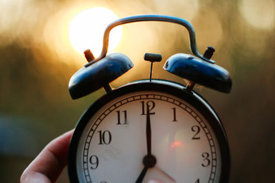 Close-up of hand holding clock