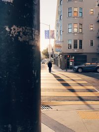 Man on street in city against sky