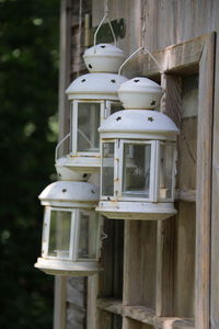 Close-up of lantern hanging against wooden house