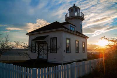 House by building against sky during sunset