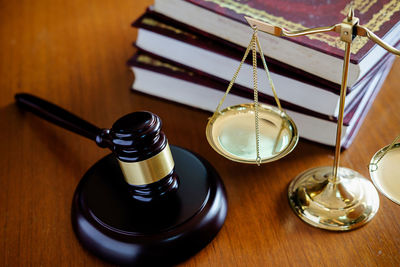 Close-up of gavel and weight scale on table in courtroom