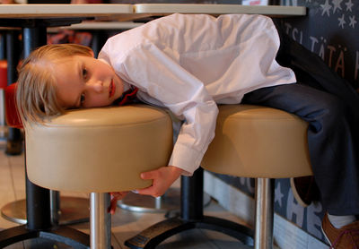 Boy lying on chair