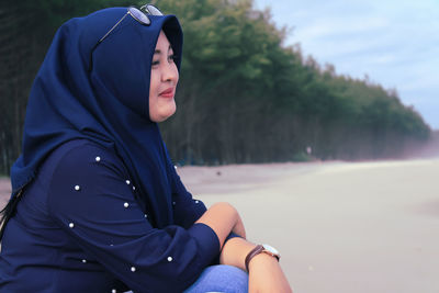 Midsection of woman sitting outdoors