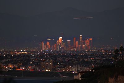 Illuminated buildings in city against sky at night