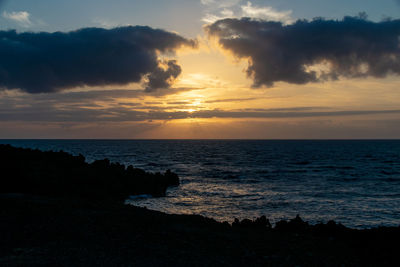 Sunrise over atlantic ocean from fuencaliente, la palma with silhouette of volcanic igneous rocks
