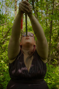 Rear view of woman standing in forest