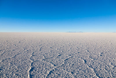 Scenic view of desert against clear blue sky