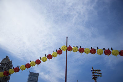 Low angle view of lanterns hanging against sky