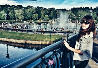 Young woman standing on footbridge over river at tsaritsyno park