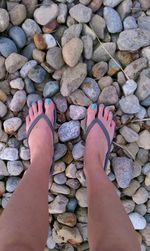 Low section of woman standing on stones