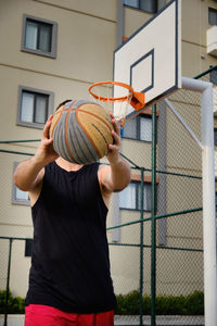 Young adult man plays basketball at outdoor court. basketball player shows his dribbling skill