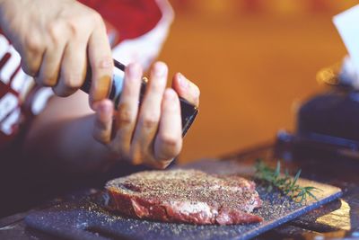 A man wearing ingredients to make a steak outdoor midsection of preparing food