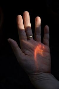 Close-up of human hand against black background