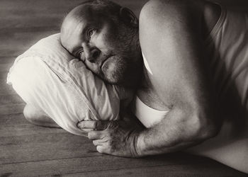 Midsection of father with baby lying on floor