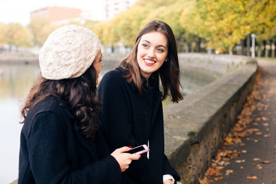 Portrait of young woman using mobile phone in winter