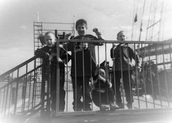 Portrait of young couple standing on railing