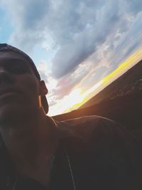 Portrait of man in car against sky during sunset