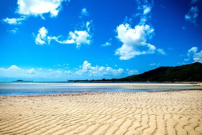 Scenic view of beach against blue sky