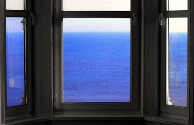 View of blue sea through window
