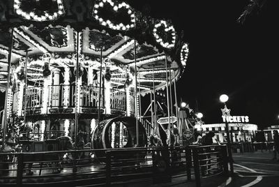 Illuminated carousel against sky at night