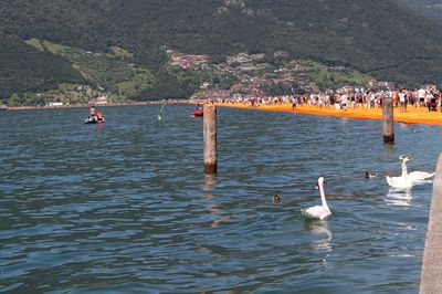 People in lake against sky