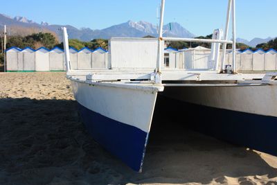 Boat moored on beach against sky