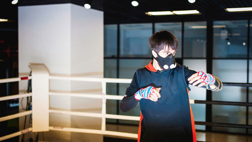 Man in mask practicing at boxing ring