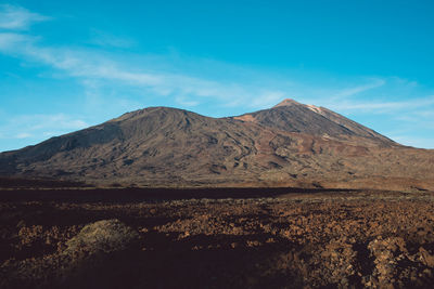 Scenic view of mountains against blue sky