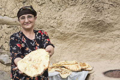Portrait of smiling woman holding bread