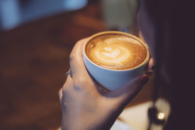 Close-up of hand holding coffee cup