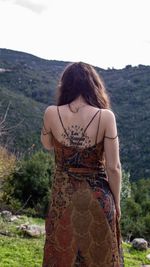 Young woman standing against mountain