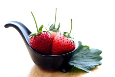 Close-up of strawberries on table against white background